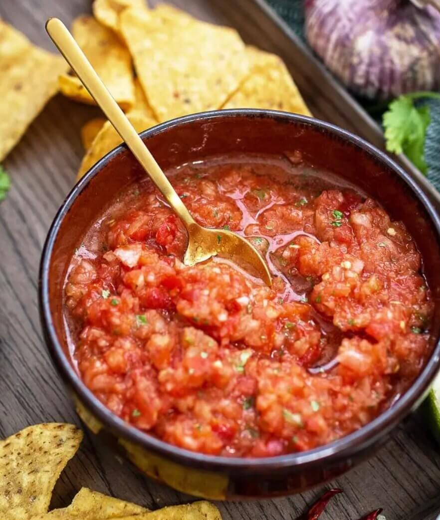 Bowl of La Costeña red sauce with chips, made from tomatoes, cilantro, and spices, perfect for all dishes.