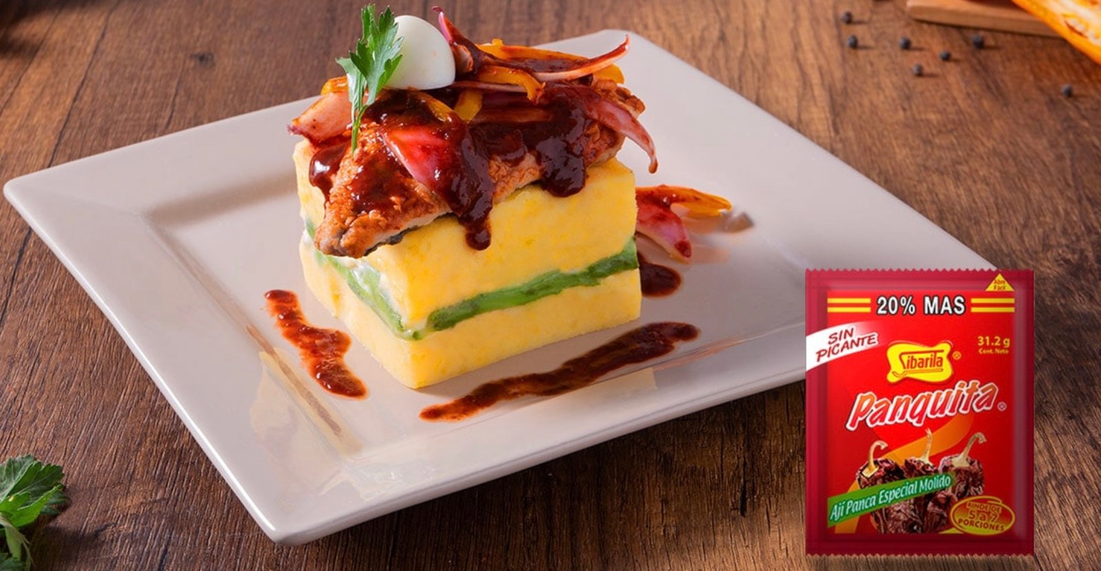 Delicious layered Peruvian dish with Ají Panca seasoning packet on the side, enhancing flavor.